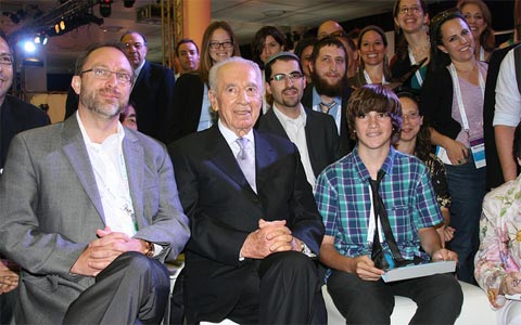 Wikipedia's Jimmy Wales and Israeli war criminal and President Shimon Peres together with Israeli-Jewish bloggers in Israel, 2011.